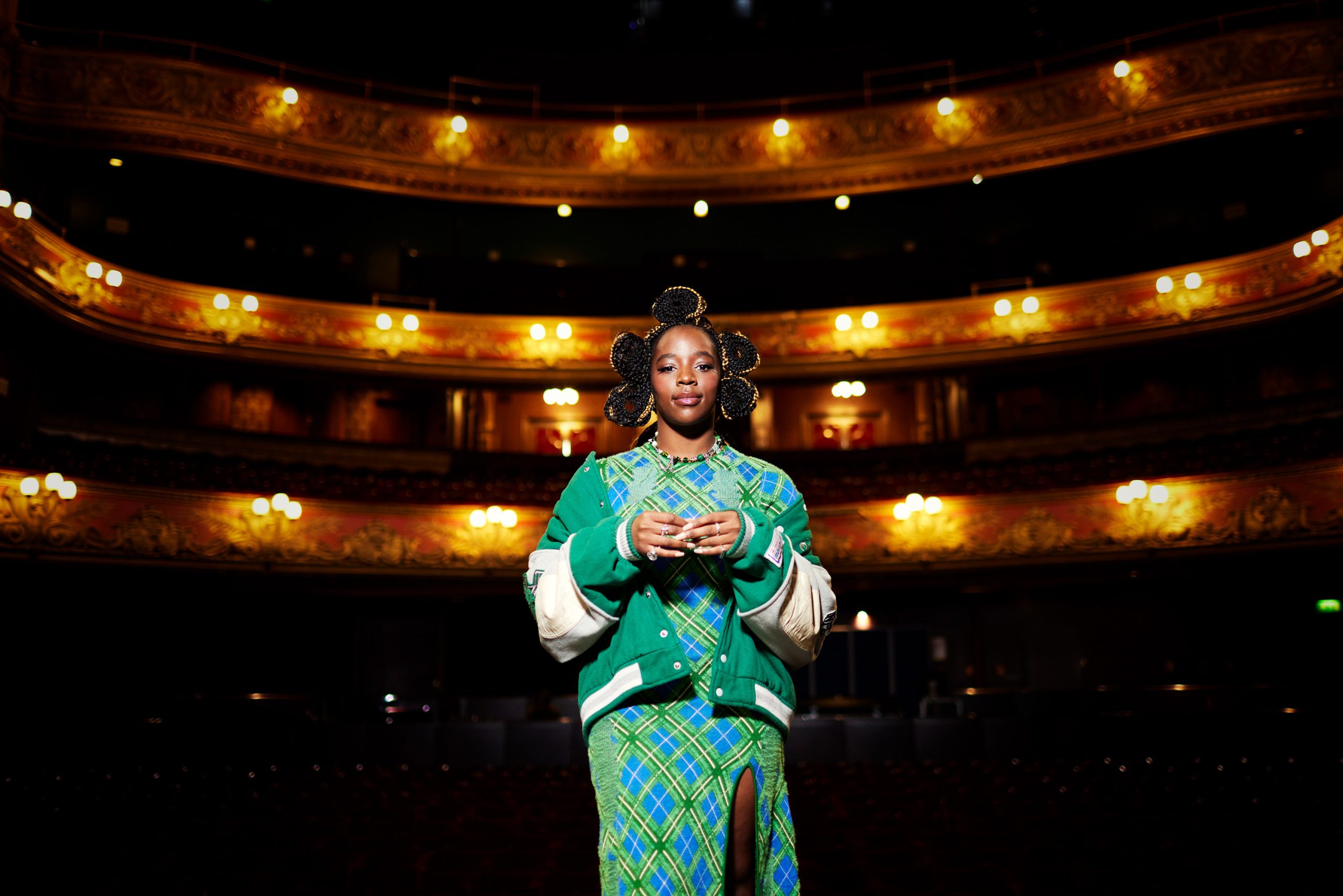 Corrina on a stage with the large theatre seating area behind her