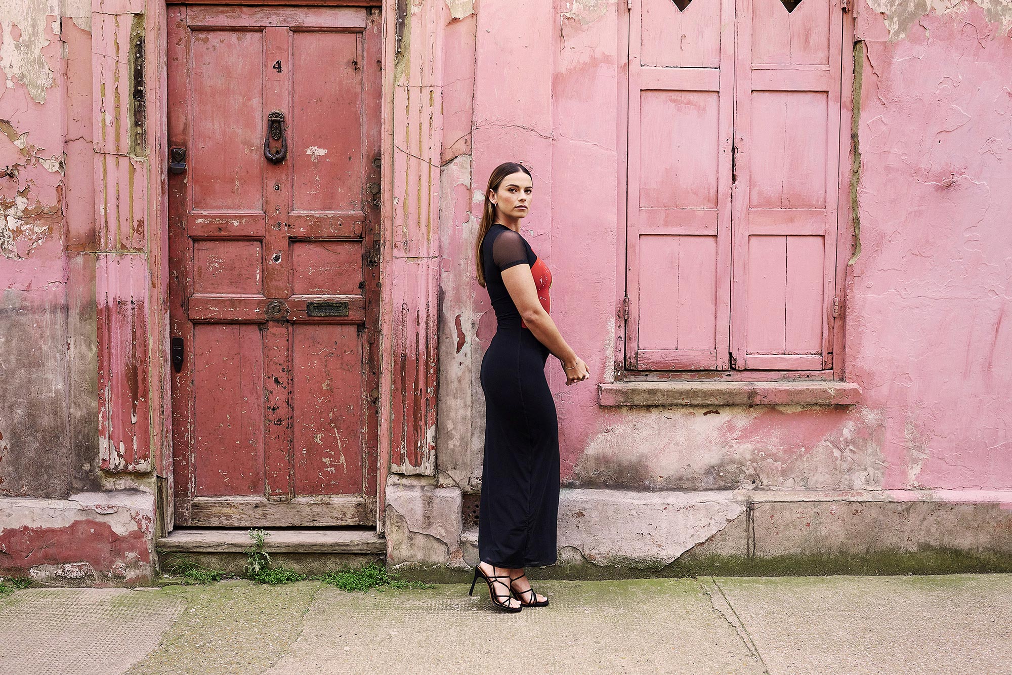 Skye standing in front of a pink building
