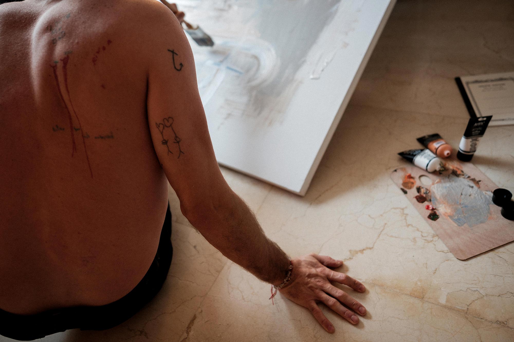 Jake sitting on the floor working on a painting