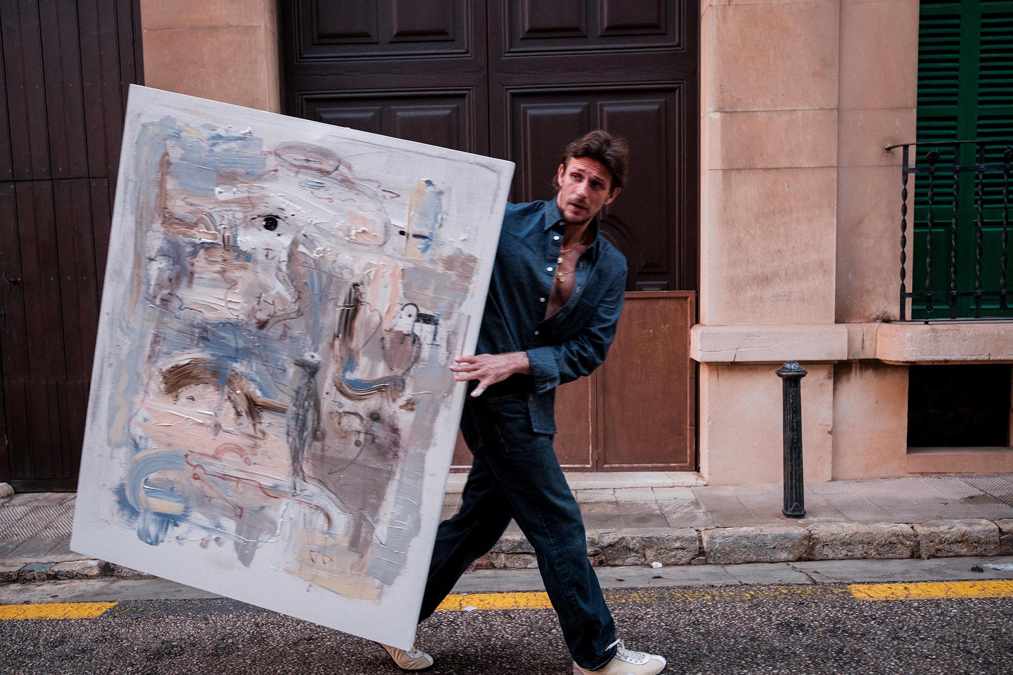 Jake carrying a painting along a street
