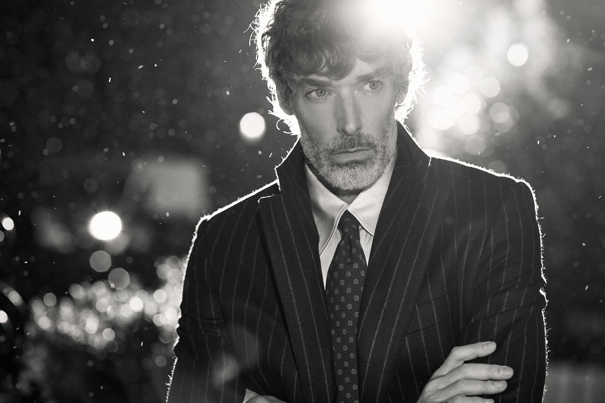 Richard wearing a suit with his arms folded