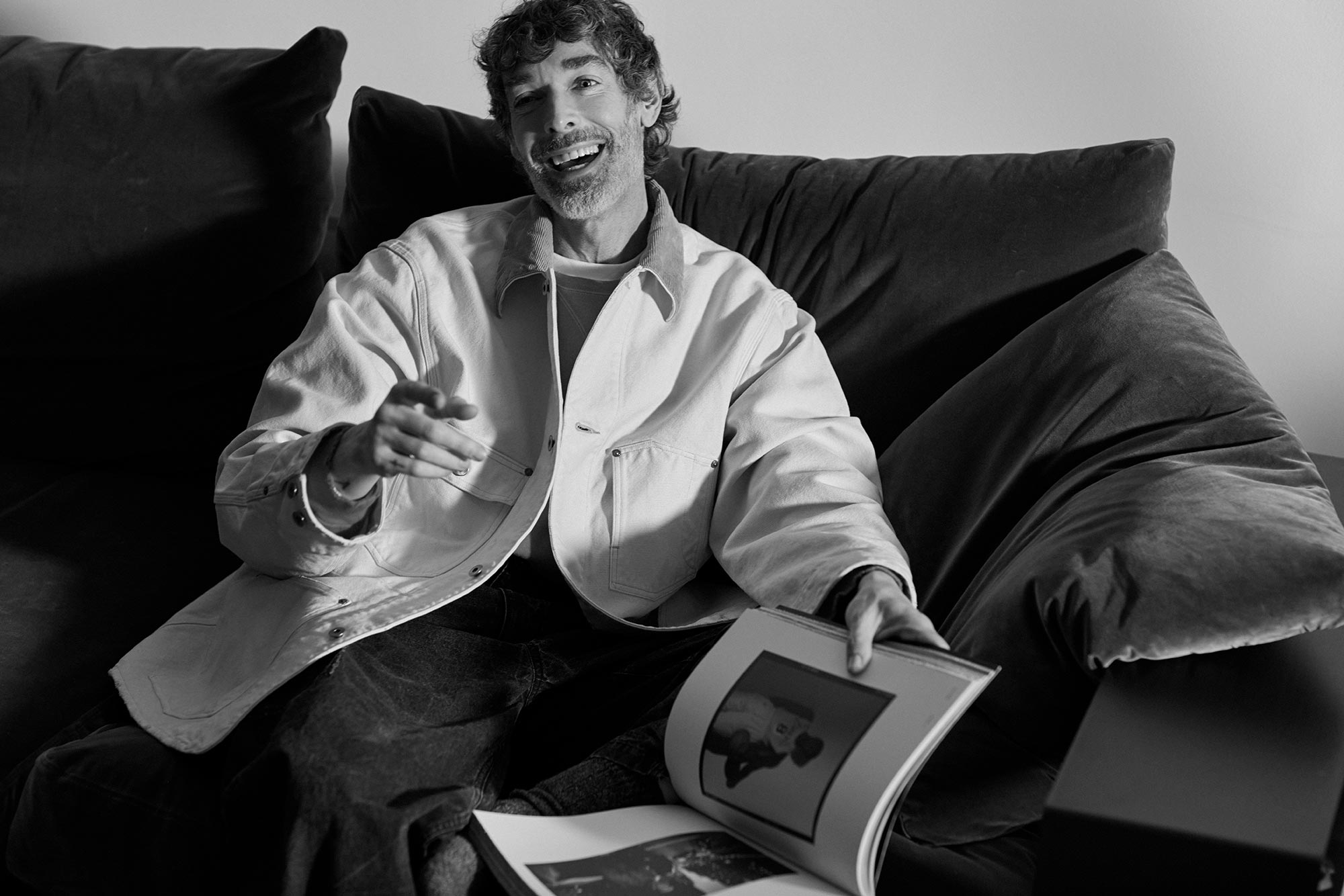 Richard sat on a sofa looking through a magazine