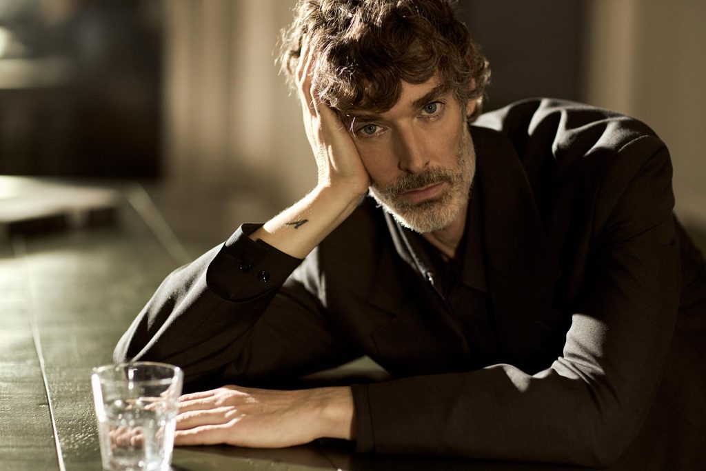 Richard leaning on a table