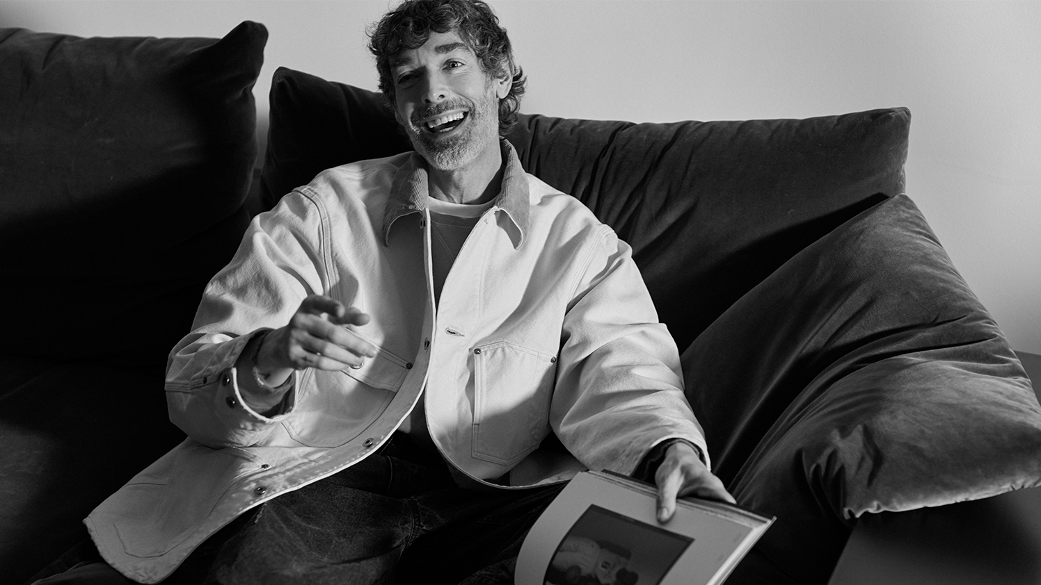 Richard sitting on a sofa reading a magazine